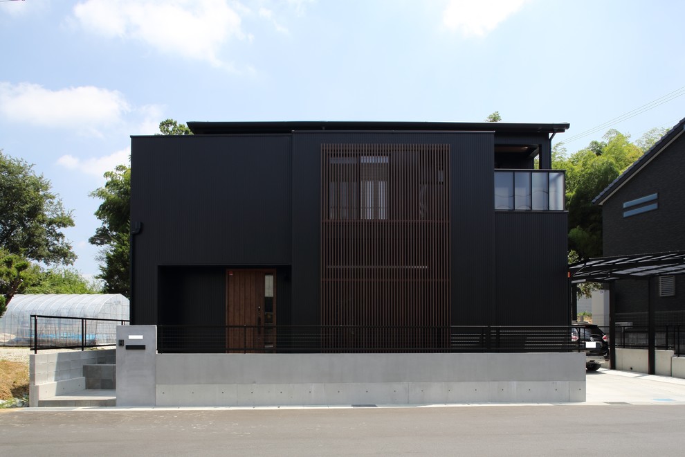 Esempio della facciata di una casa nera moderna di medie dimensioni con tetto piano