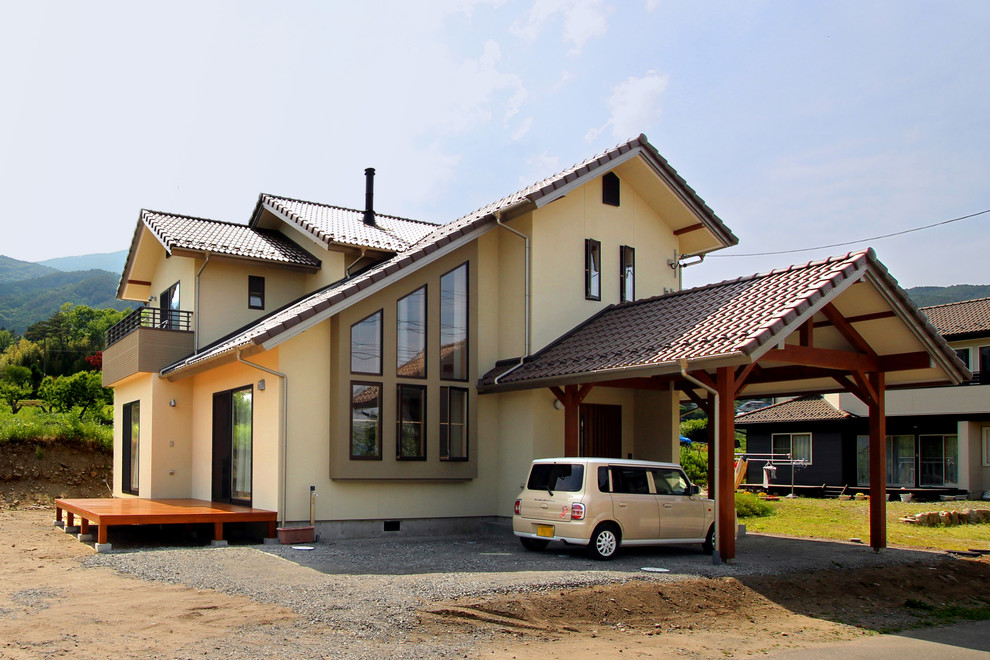 Exempel på ett mellanstort asiatiskt beige hus, med två våningar, sadeltak och tak med takplattor