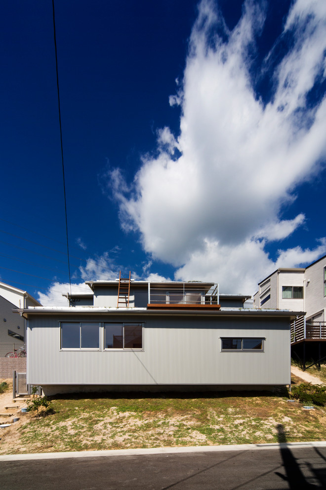 Идея дизайна: серый частный загородный дом в современном стиле с зеленой крышей