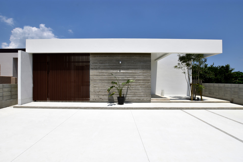 Cette photo montre une façade de maison blanche moderne avec un toit plat.