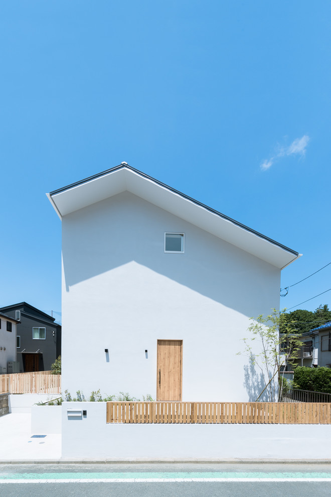 Ejemplo de fachada blanca minimalista con tejado a dos aguas