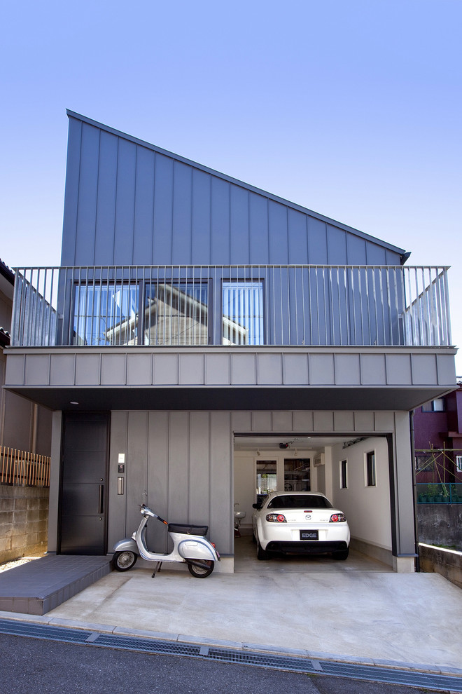 Immagine della facciata di una casa piccola grigia contemporanea a due piani con rivestimento in metallo e copertura in metallo o lamiera