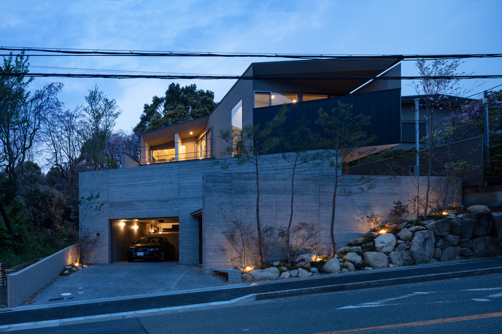 Ispirazione per la facciata di una casa grigia moderna a piani sfalsati di medie dimensioni con rivestimento in cemento e copertura in metallo o lamiera
