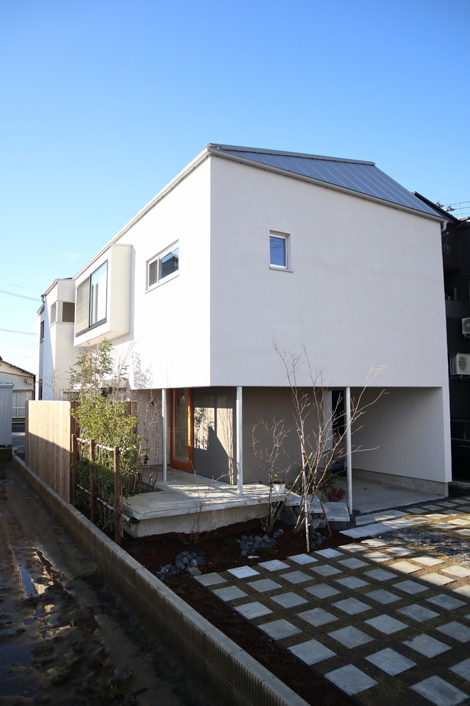 White modern two floor detached house with a metal roof.