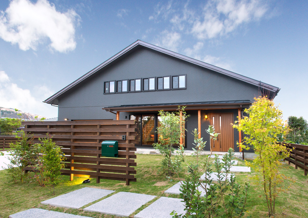 Ejemplo de fachada de casa negra asiática de dos plantas con tejado a dos aguas y tejado de metal