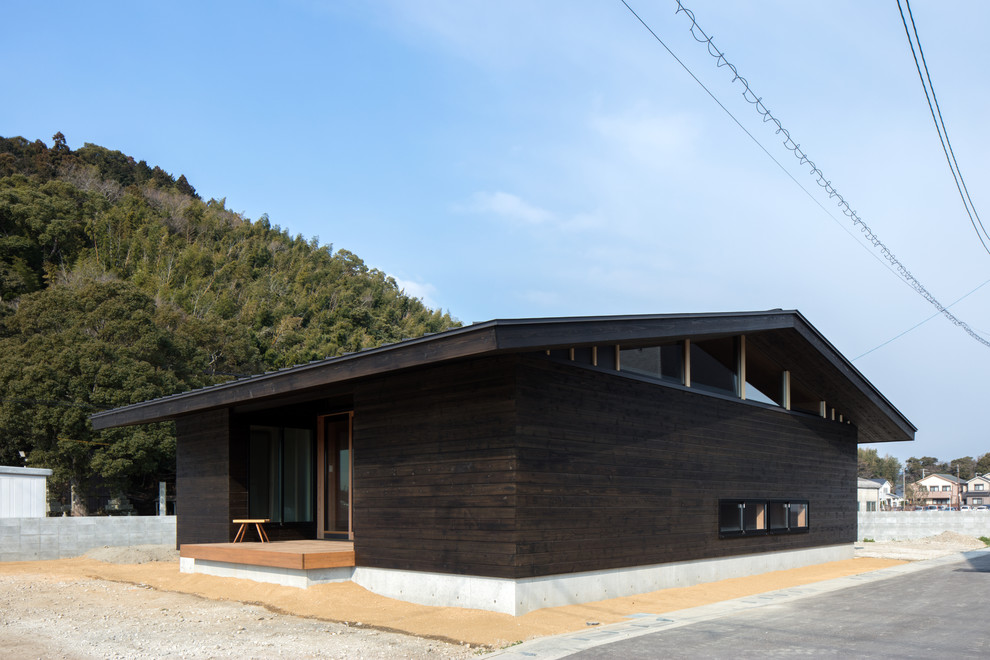Свежая идея для дизайна: черный дом в восточном стиле с двускатной крышей - отличное фото интерьера