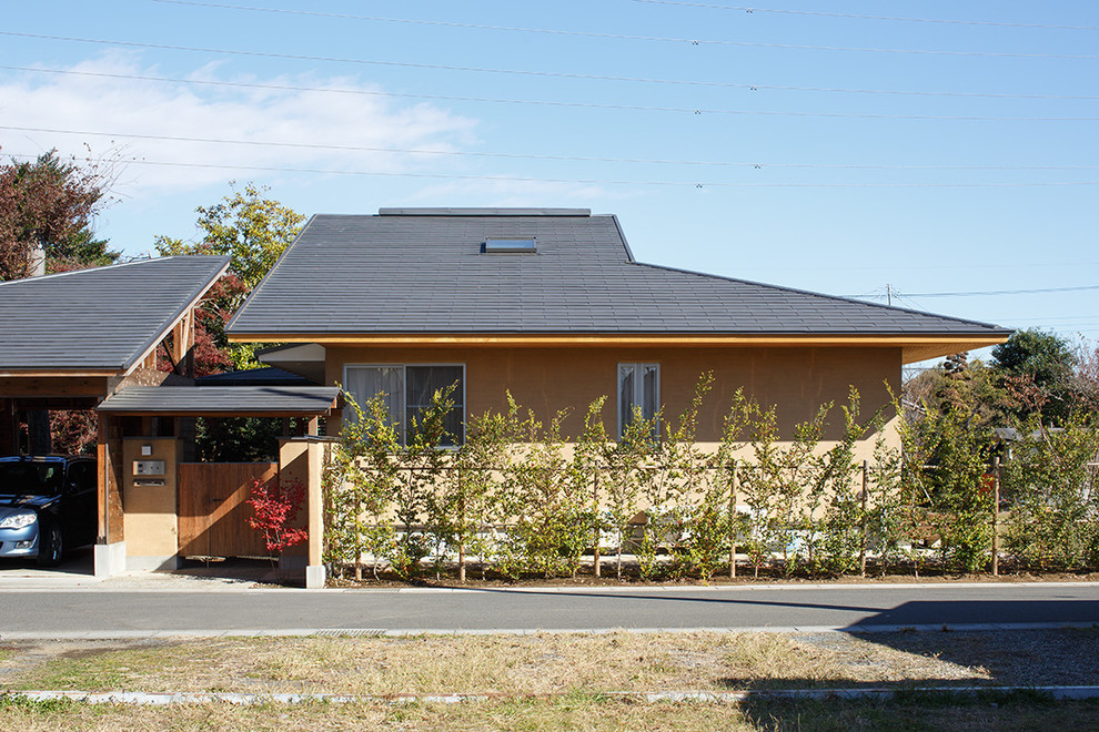 Mittelgroßes, Einstöckiges Asiatisches Einfamilienhaus mit Putzfassade, beiger Fassadenfarbe, Walmdach und Blechdach in Sonstige