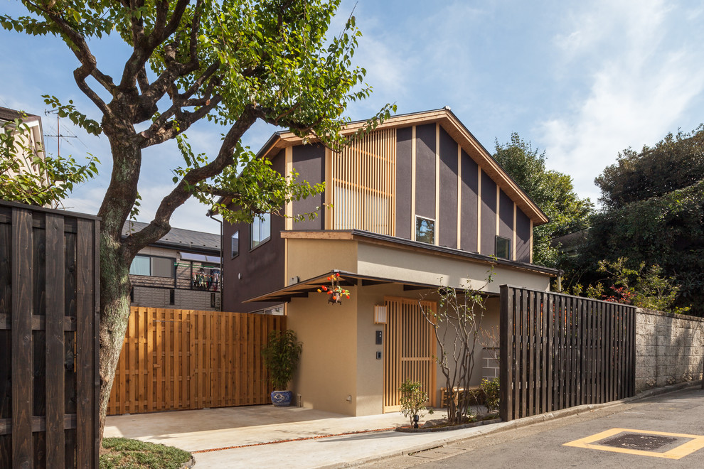 Foto de fachada de casa marrón de estilo zen de tamaño medio de dos plantas con tejado a dos aguas, revestimiento de estuco y tejado de metal