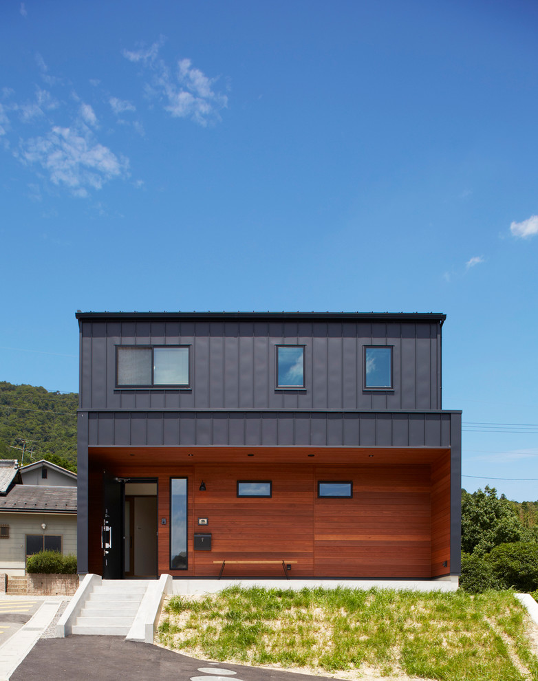 На фото: двухэтажный, деревянный, черный дом в современном стиле с плоской крышей с