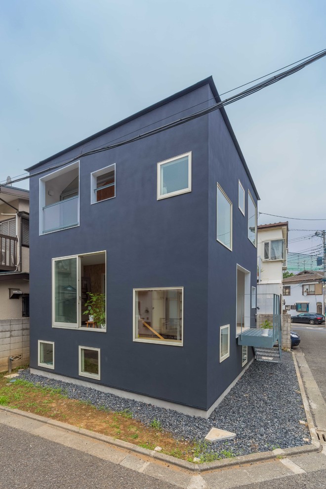 This is an example of a gey contemporary split-level house exterior in Tokyo with a hip roof.