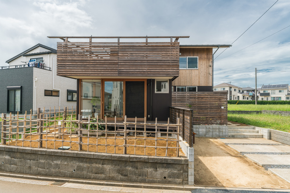 Cette photo montre une façade de maison marron asiatique en bois avec un toit plat.
