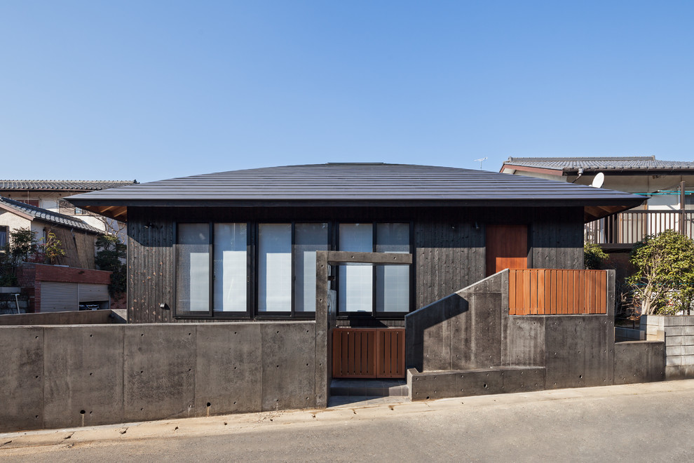 Asiatische Holzfassade Haus mit schwarzer Fassadenfarbe und Mansardendach in Sonstige
