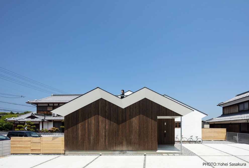 Inspiration pour une façade de maison marron asiatique en bois de taille moyenne et de plain-pied avec un toit à deux pans.