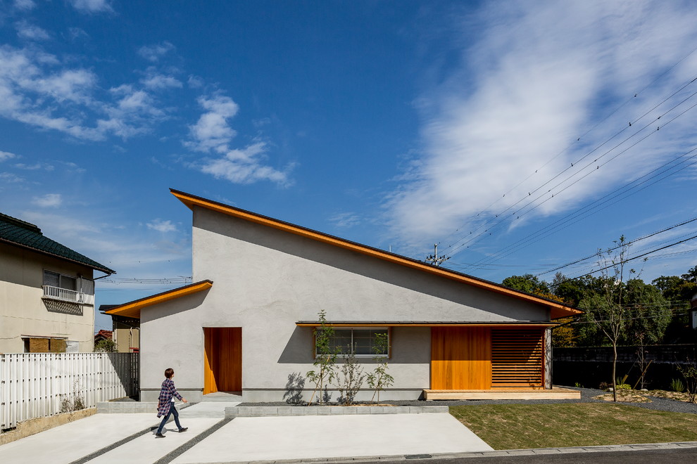 Imagen de fachada de casa gris asiática con tejado de un solo tendido