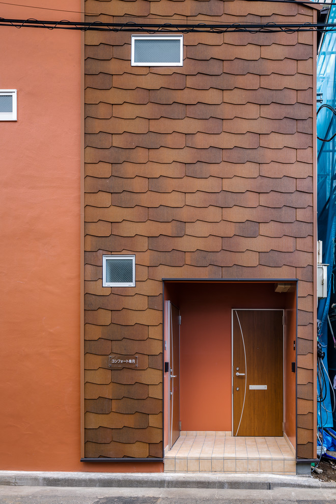 Mittelgroßes, Zweistöckiges Nordisches Wohnung mit Mix-Fassade, oranger Fassadenfarbe, Satteldach, Misch-Dachdeckung, rotem Dach und Verschalung in Sonstige