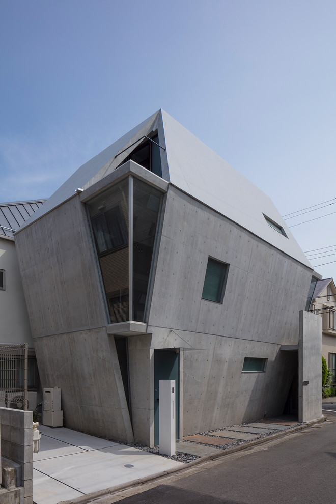 This is an example of a gey contemporary concrete detached house in Tokyo with three floors.