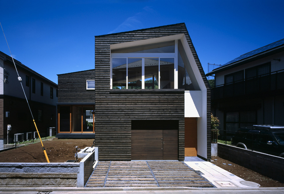 Modelo de fachada negra contemporánea de tamaño medio de dos plantas con revestimiento de madera y tejado a dos aguas