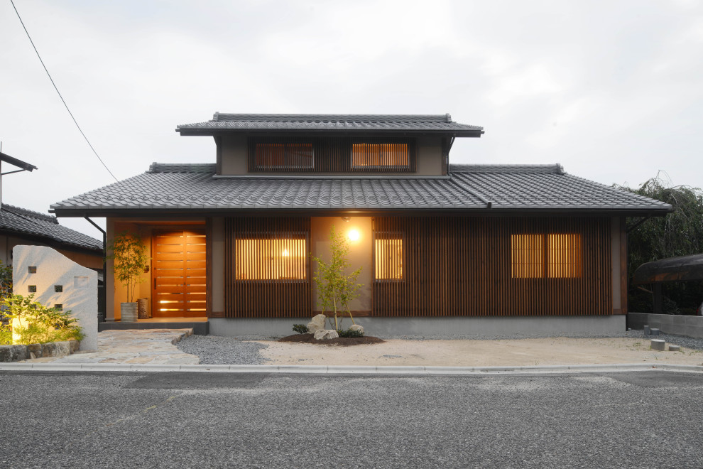 Modelo de fachada de casa marrón y gris de estilo zen de dos plantas con revestimiento de madera, tejado a dos aguas y tejado de teja de barro