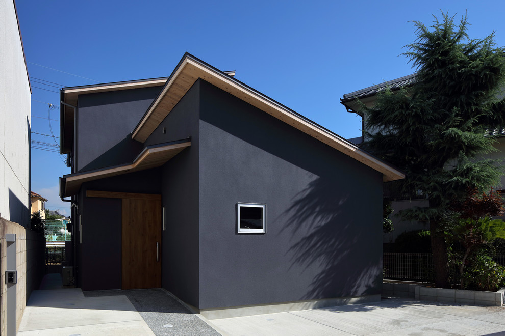Réalisation d'une façade de maison bleue asiatique à un étage avec un toit en appentis, un toit en métal et boîte aux lettres.