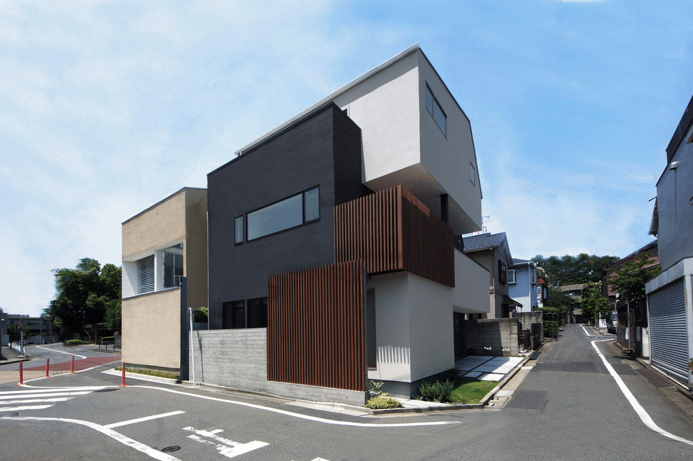 Mittelgroßes, Dreistöckiges Asiatisches Haus mit schwarzer Fassadenfarbe und Flachdach in Tokio