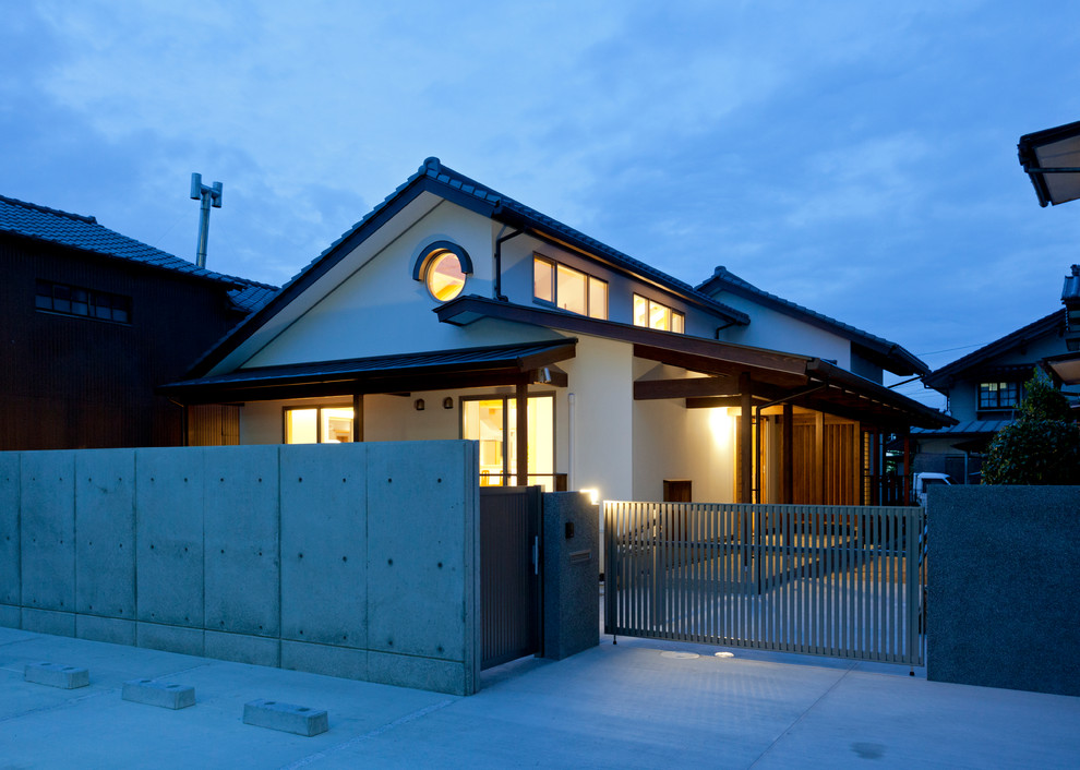 Kleines, Einstöckiges Asiatisches Einfamilienhaus mit weißer Fassadenfarbe, Satteldach und Ziegeldach in Sonstige