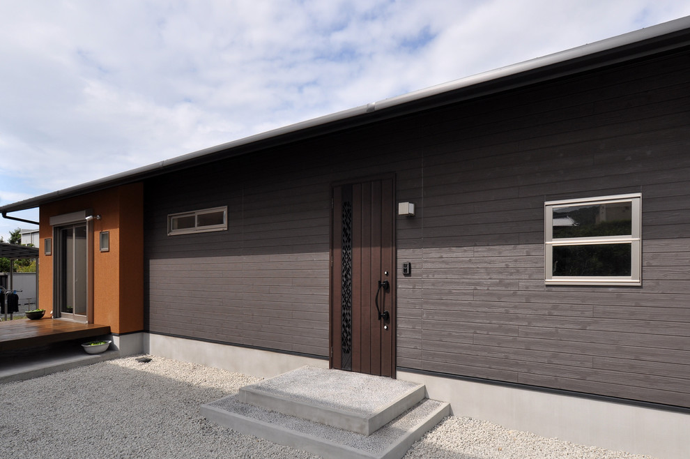 Exempel på ett modernt brunt hus, med allt i ett plan, blandad fasad, pulpettak och tak i metall