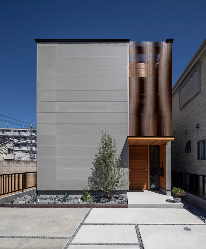 Idée de décoration pour une façade de maison grise asiatique à un étage avec un revêtement mixte et un toit plat.