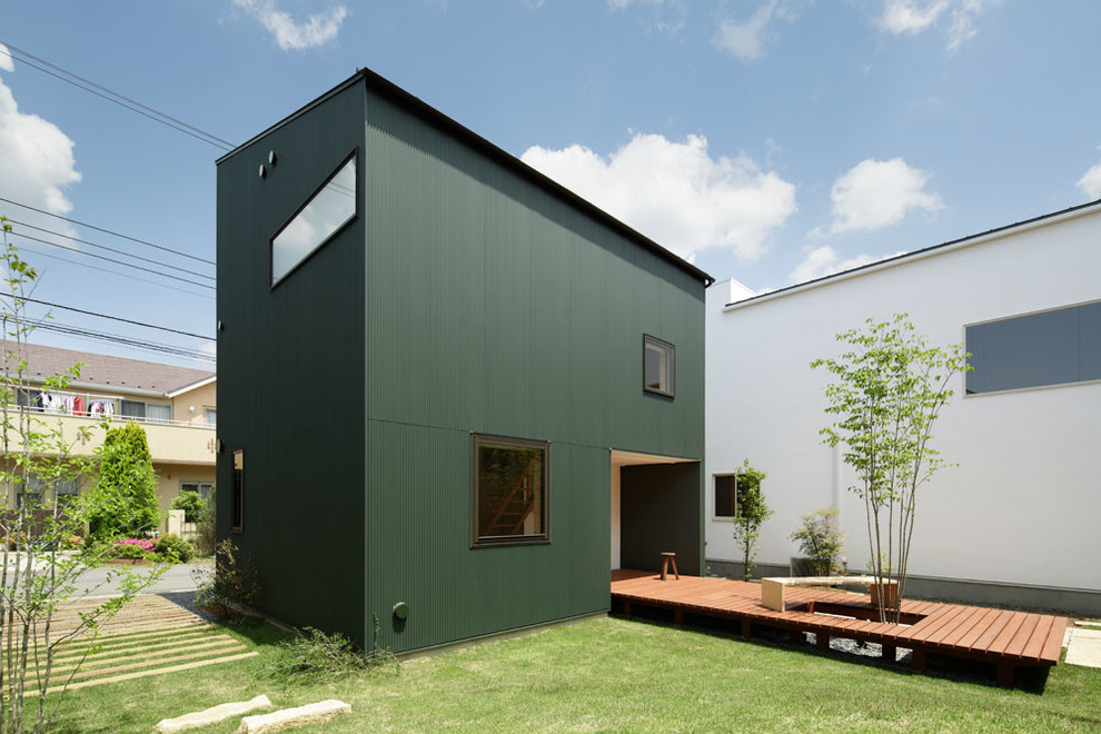 На фото: двухэтажный, зеленый дом из контейнеров в восточном стиле с облицовкой из металла и плоской крышей с