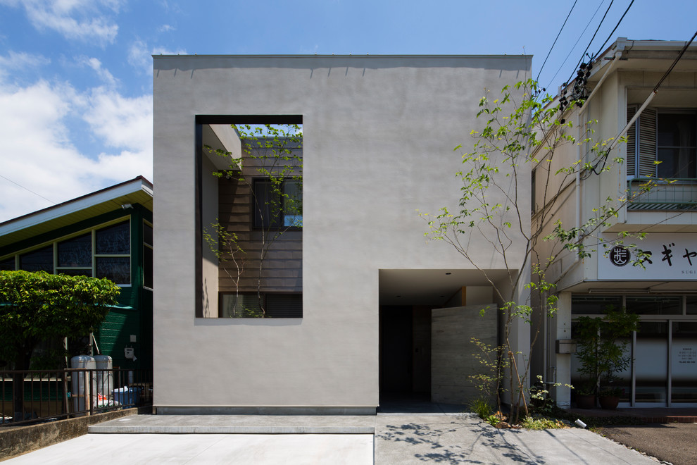 Ispirazione per la facciata di una casa grigia contemporanea con rivestimento in cemento
