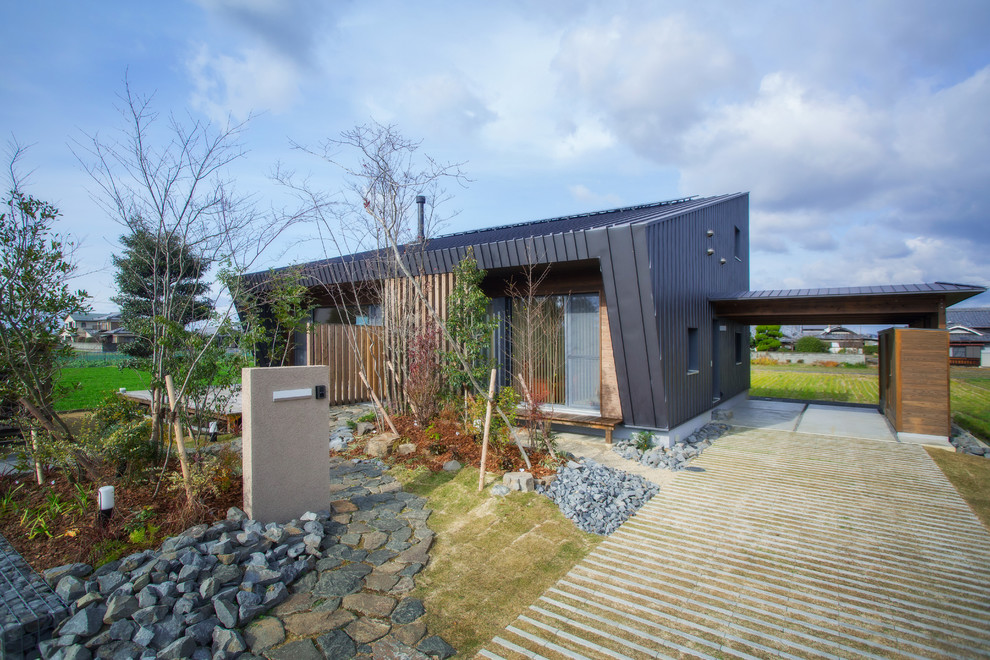 Photo of a black contemporary house exterior in Yokohama with a lean-to roof.