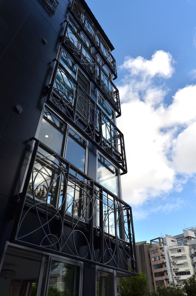 Foto de fachada negra de estilo zen de tres plantas con revestimiento de vidrio y tejado a dos aguas
