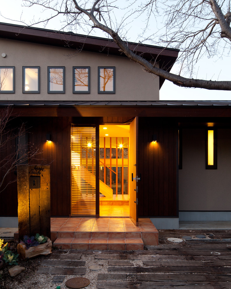 Esempio della facciata di una casa marrone country a due piani con rivestimento in legno e copertura in metallo o lamiera