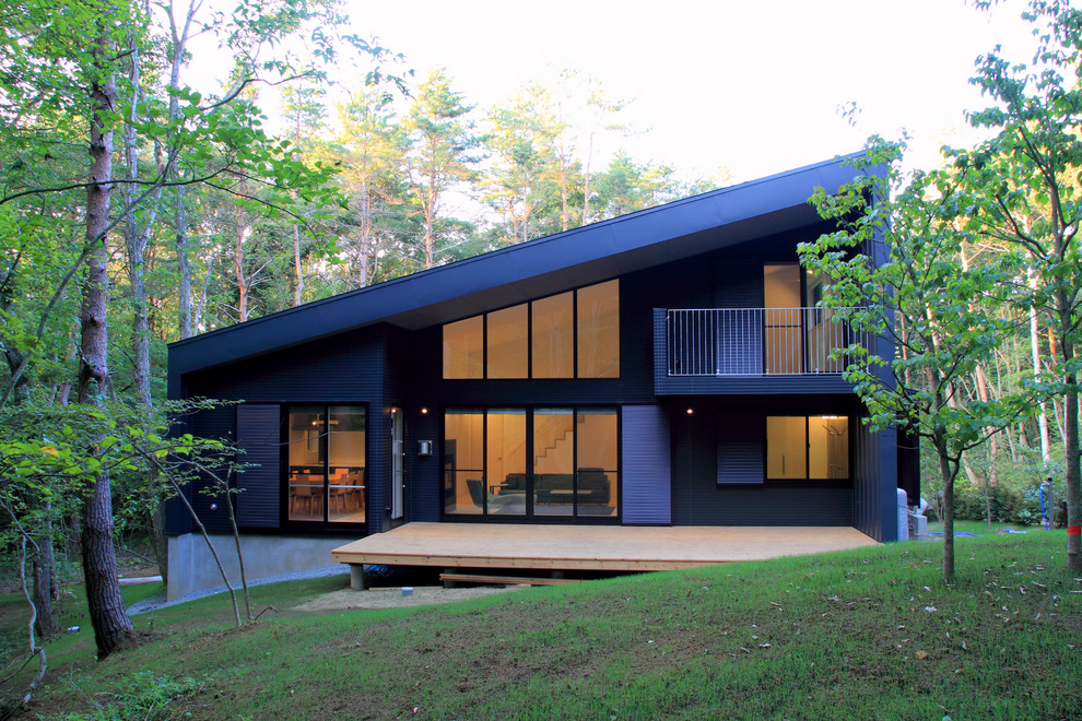 Idées déco pour une façade de maison métallique et grise moderne de taille moyenne et à un étage avec un toit en appentis et un toit en métal.