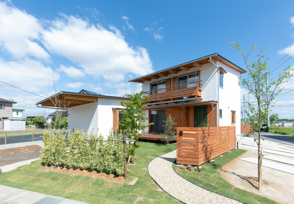 Kleines, Zweistöckiges Asiatisches Einfamilienhaus mit Putzfassade, weißer Fassadenfarbe und Pultdach in Sonstige