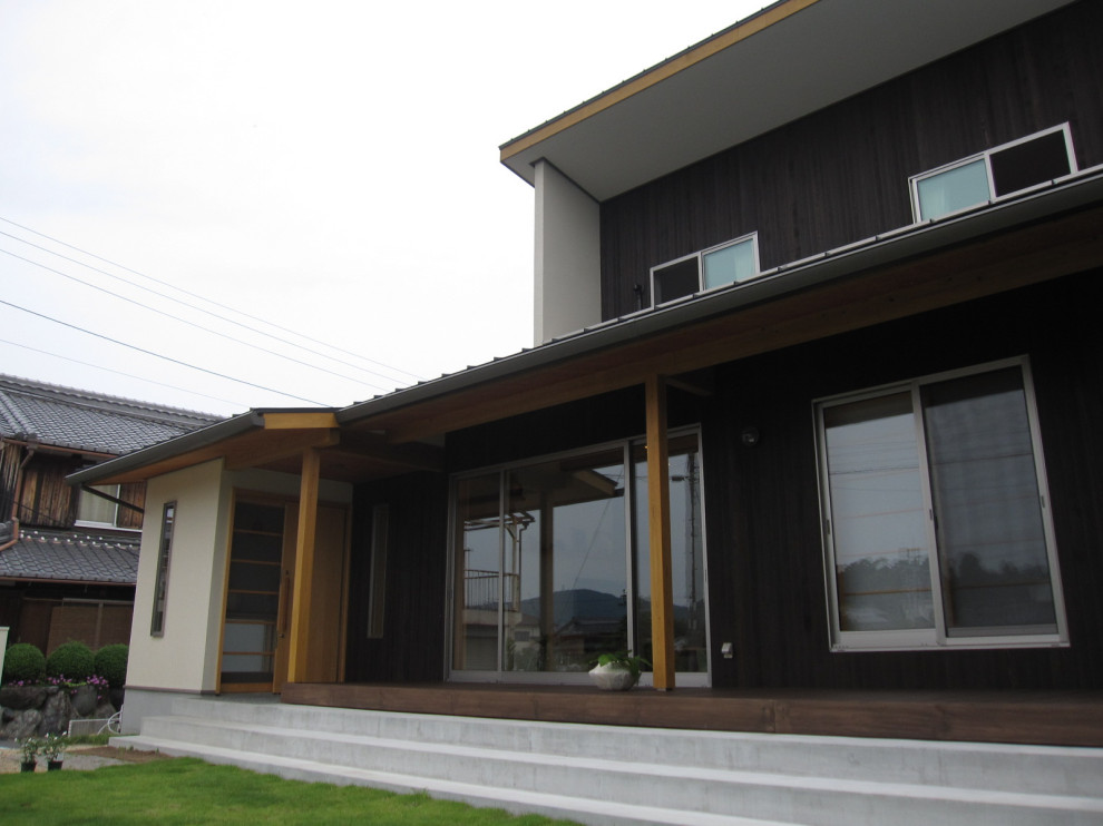 Foto della facciata di una casa nera scandinava a due piani di medie dimensioni con rivestimento in legno e copertura in metallo o lamiera