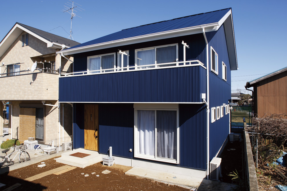 Пример оригинального дизайна: двухэтажный, синий частный загородный дом в стиле модернизм с двускатной крышей, металлической крышей и синей крышей