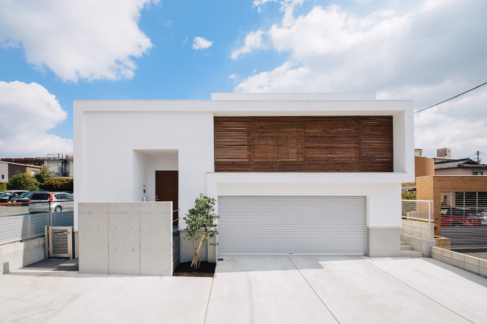 Esempio della facciata di una casa bianca moderna a piani sfalsati con rivestimento in cemento e copertura in metallo o lamiera