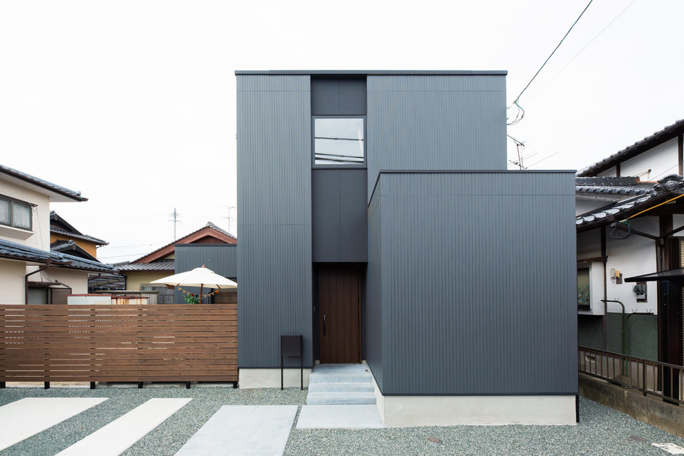 Imagen de fachada de casa negra industrial de tamaño medio de dos plantas con revestimientos combinados, tejado de un solo tendido y tejado de metal