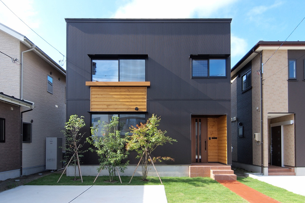 Immagine della facciata di una casa nera contemporanea con tetto piano