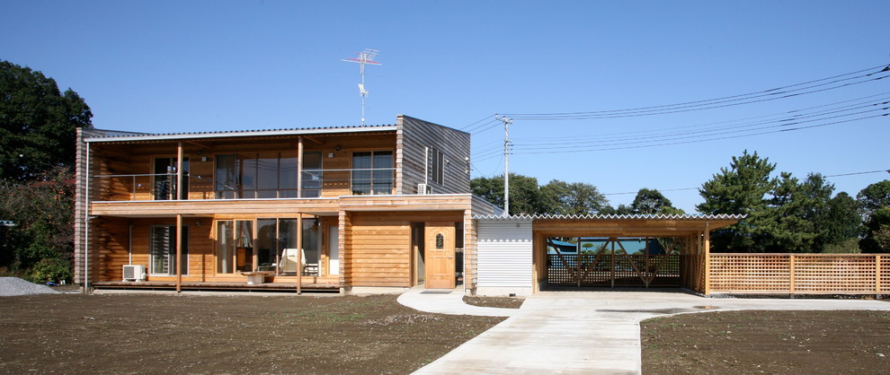 Exemple d'une façade de maison marron nature en bois de taille moyenne et à un étage avec un toit en appentis et un toit en métal.