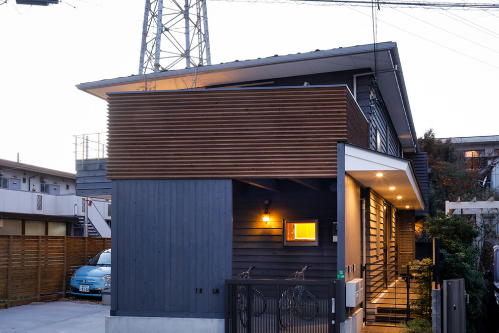 Inspiration for a medium sized and gey country detached house in Tokyo with three floors, wood cladding, a hip roof and a metal roof.