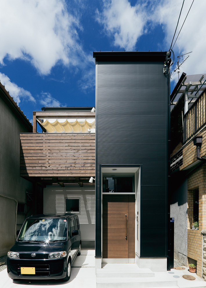 Immagine della facciata di una casa nera moderna con tetto piano