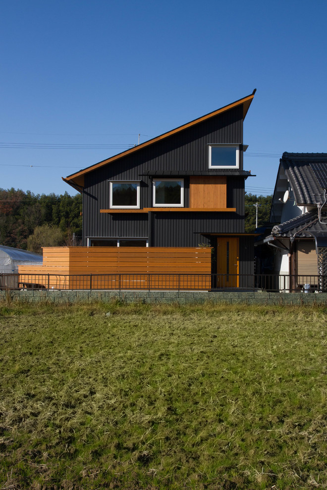 Modelo de fachada de casa negra moderna de dos plantas con tejado de un solo tendido y tejado de metal