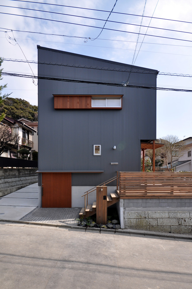 Foto på ett minimalistiskt hus, med pulpettak och tak i metall