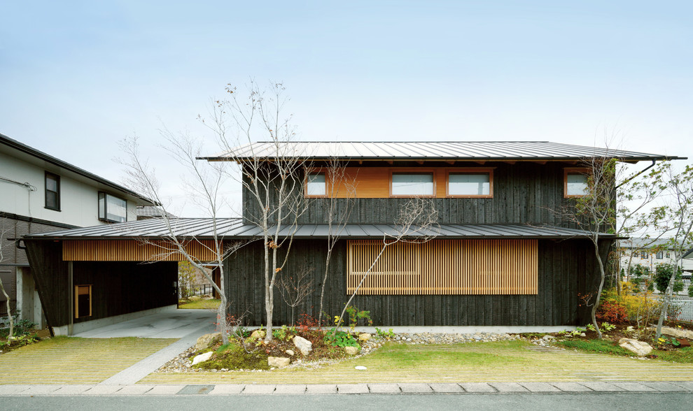 Cette photo montre une façade de maison noire en bois à un étage avec un toit en appentis, un toit en métal et boîte aux lettres.