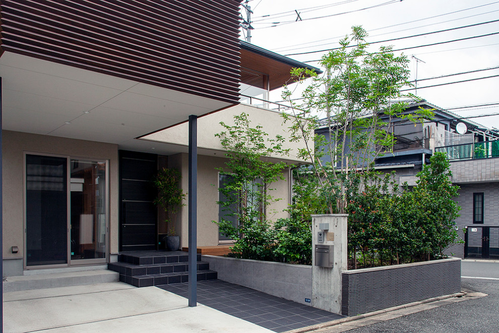 Mittelgroßes, Zweistöckiges Modernes Einfamilienhaus mit Putzfassade, beiger Fassadenfarbe, Walmdach und Blechdach in Tokio