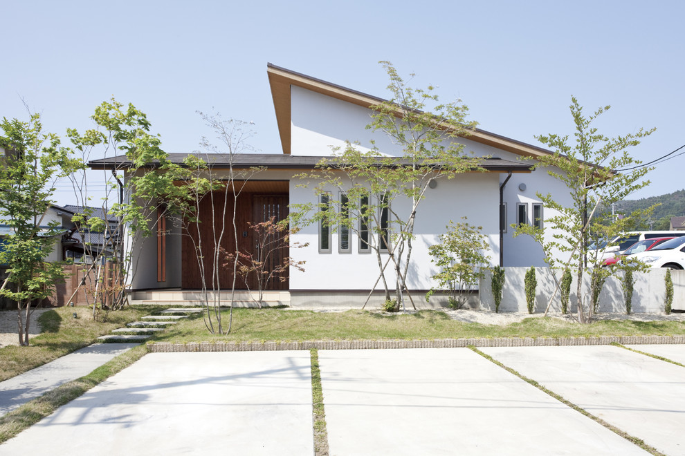 Mittelgroßes Asiatisches Einfamilienhaus mit weißer Fassadenfarbe und Pultdach in Sonstige