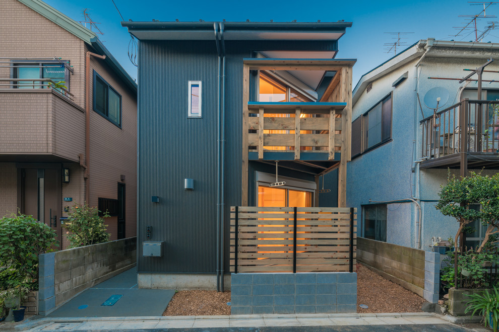 Zweistöckiges Modernes Einfamilienhaus mit Metallfassade, grauer Fassadenfarbe und Flachdach in Tokio