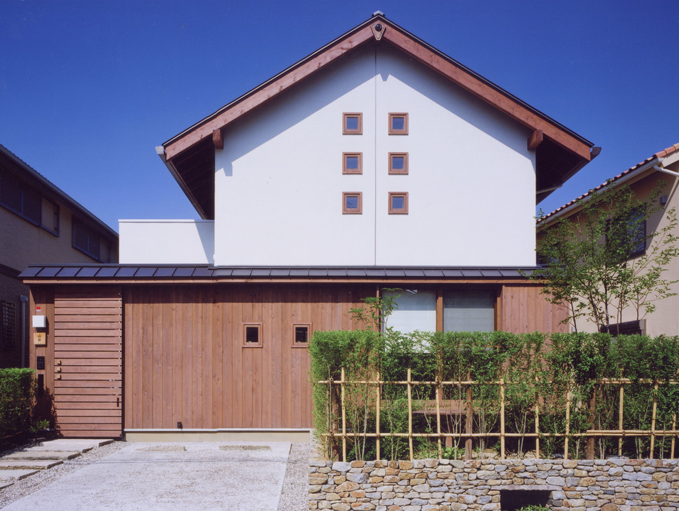 Aménagement d'une petite façade de maison marron asiatique en bois à un étage avec un toit à deux pans et un toit en métal.