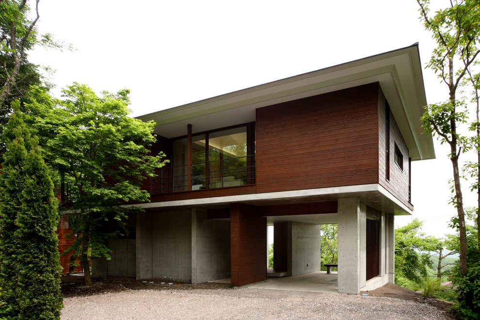 Diseño de fachada de casa marrón actual de tamaño medio de dos plantas con revestimiento de madera, tejado a cuatro aguas y tejado de metal